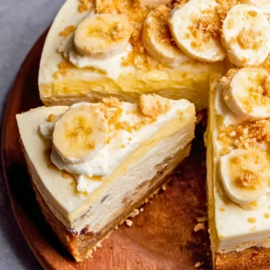 Delicious banana pudding cheesecake slice topped with whipped cream and banana slices.