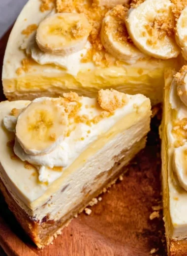 Delicious banana pudding cheesecake slice topped with whipped cream and banana slices.