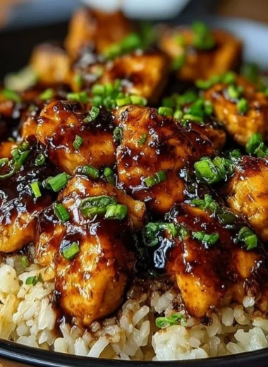 Plate of Honey BBQ Chicken served over rice, garnished with green onions.