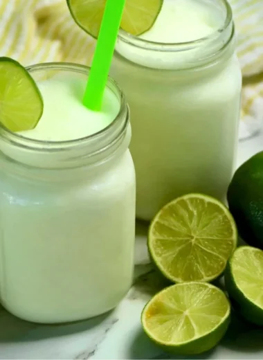 Refreshing Brazilian Lemonade with Coconut served in a glass with lime slices