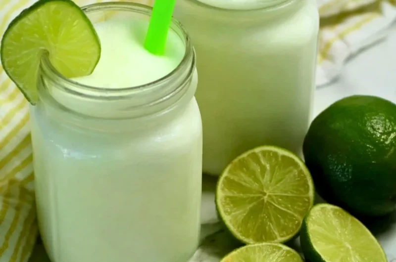 Refreshing Brazilian Lemonade with Coconut served in a glass with lime slices
