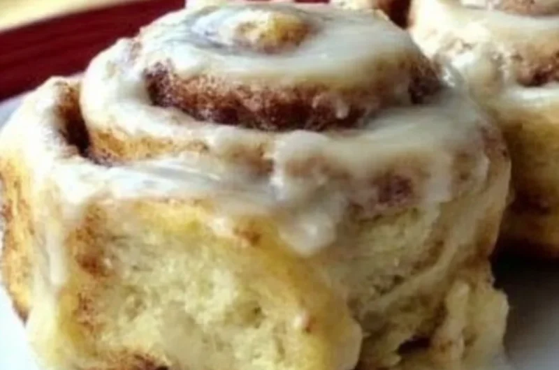 Freshly baked homemade cinnamon rolls with icing on a plate