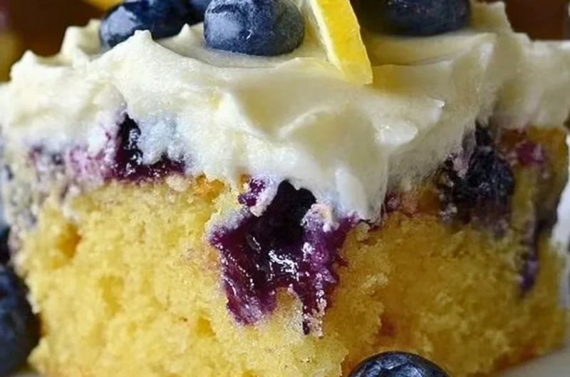 Delicious Lemon Blueberry Poke Cake topped with whipped cream and fresh blueberries