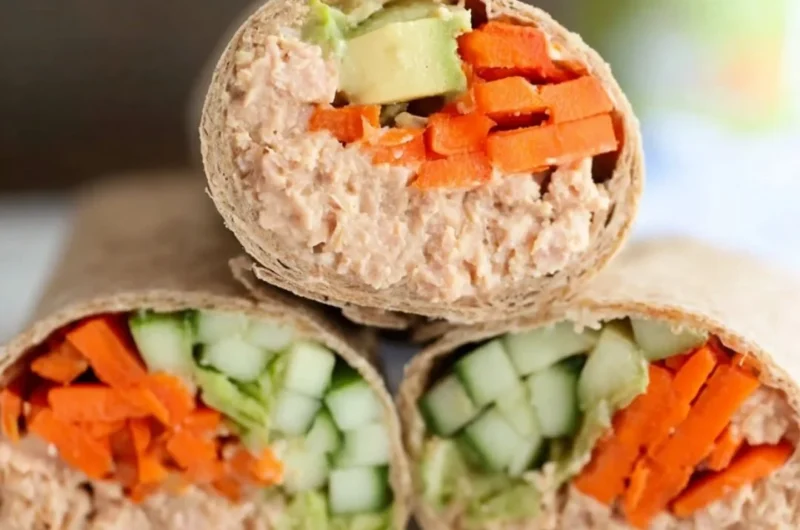 Delicious spicy tuna wraps on a plate garnished with fresh vegetables.