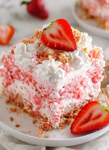 Delicious strawberry crunch poke cake topped with whipped cream and strawberry crunch topping.