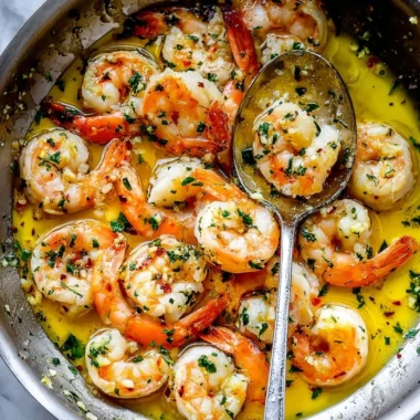 Plate of delicious shrimp scampi garnished with herbs and lemon