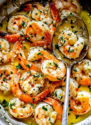 Plate of delicious shrimp scampi garnished with herbs and lemon