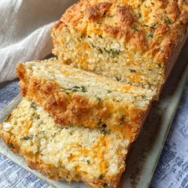 Freshly baked Cheddar Bay Biscuit Bread served on a wooden platter.