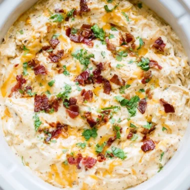 Delicious bowl of creamy Crack Chicken topped with herbs