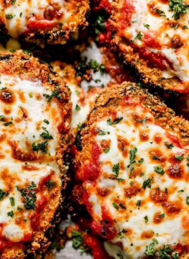 Crispy Baked Eggplant Parmesan served with fresh herbs and marinara sauce
