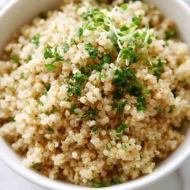 Bowl of herb and garlic quinoa garnished with fresh herbs