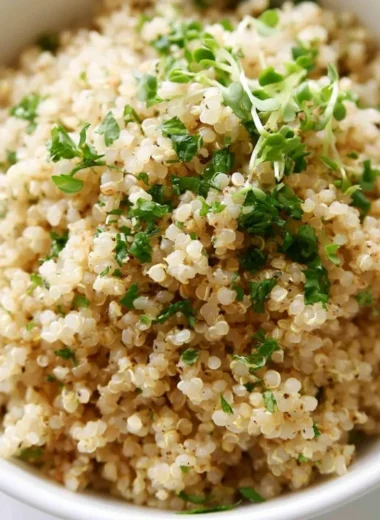 Bowl of herb and garlic quinoa garnished with fresh herbs
