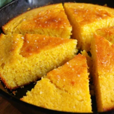 Slice of old-fashioned cornbread served on a wooden plate
