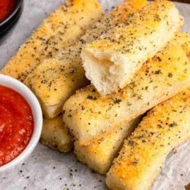 Homemade sheet pan breadsticks served on a rustic wooden table