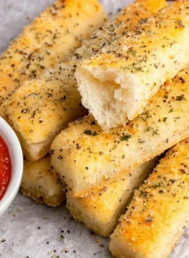 Homemade sheet pan breadsticks served on a rustic wooden table