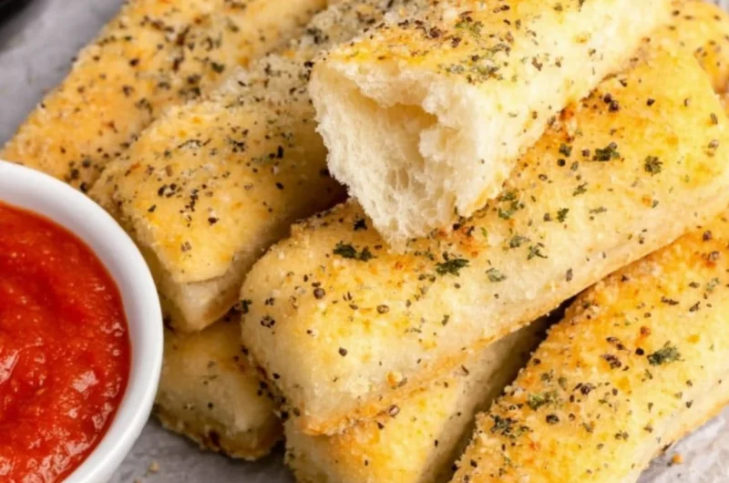 Homemade sheet pan breadsticks served on a rustic wooden table