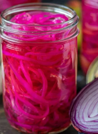Quickly pickled red onions in a jar, perfect for enhancing meals with flavor.