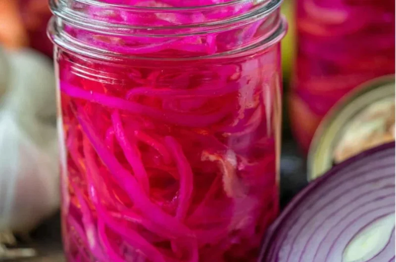 Quickly pickled red onions in a jar, perfect for enhancing meals with flavor.