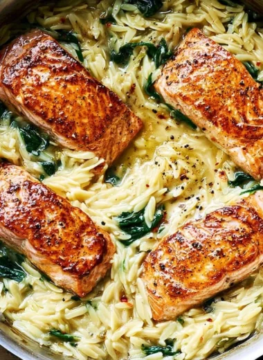 Pan-seared salmon with lemon orzo and spinach on a plate