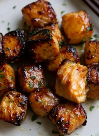 Air fryer honey garlic salmon bites served on a plate with garnish