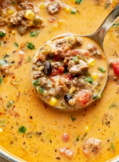 Bowl of creamy taco soup topped with cheese and cilantro