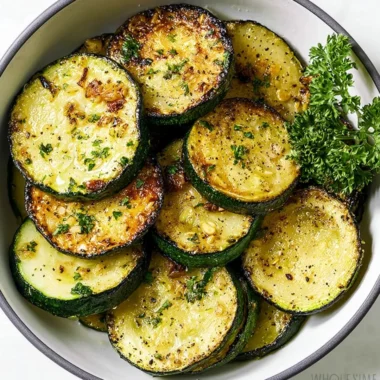 A plate of sautéed zucchini garnished with spices and herbs.