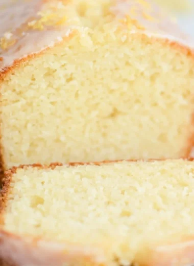 A beautiful slice of sourdough discard lemon cake on a white plate.