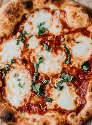 A freshly baked sourdough pizza with a golden crispy crust and colorful toppings.