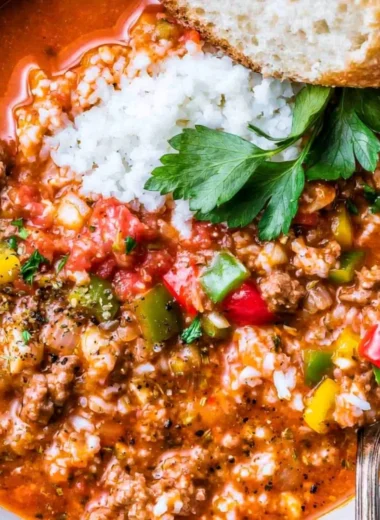Bowl of stuffed bell pepper soup with colorful vegetables and herbs